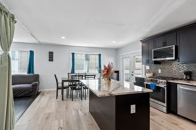 a kitchen with granite countertop kitchen island a sink table and chairs