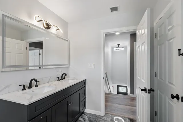 a bathroom with a sink vanity granite tub and shower