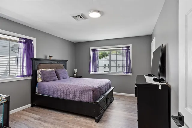 a bedroom with a bed and a flat tv screen on a dresser