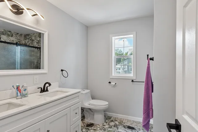 a bathroom with a sink vanity granite and toilet