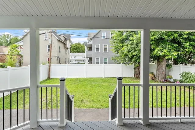 a porch with a bench next to a yard