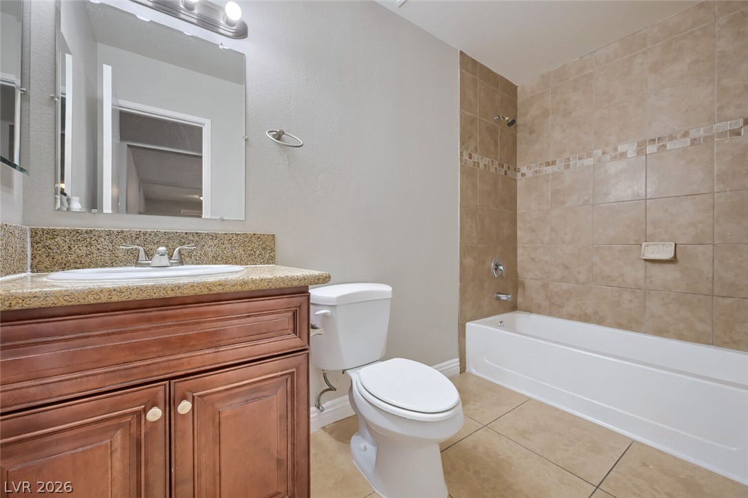 6321 Portola Road Las Vegas, NV 89108 - Photo 23 of 29 Granite counters and tiled bath surround enhance this functional bathroom space.