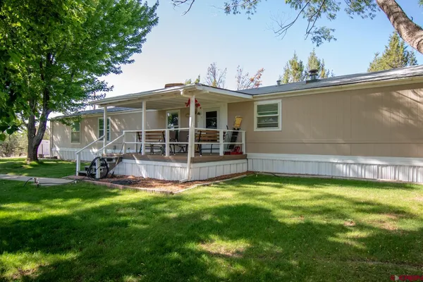 a view of a house with a swimming pool and a yard