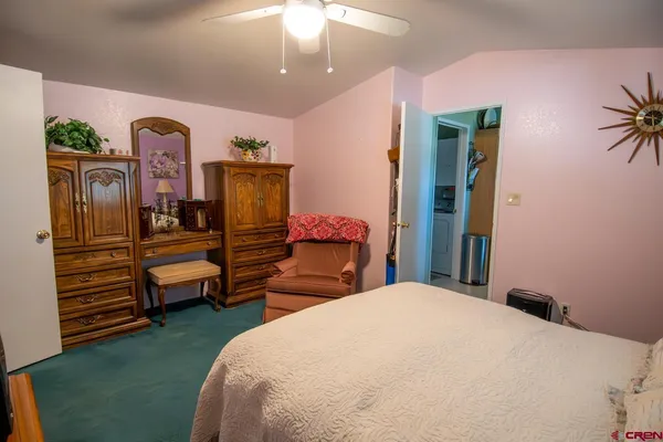 a bedroom with a bed and dresser with mirror