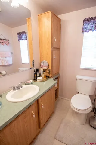 a bathroom with a double vanity sink toilet and a mirror