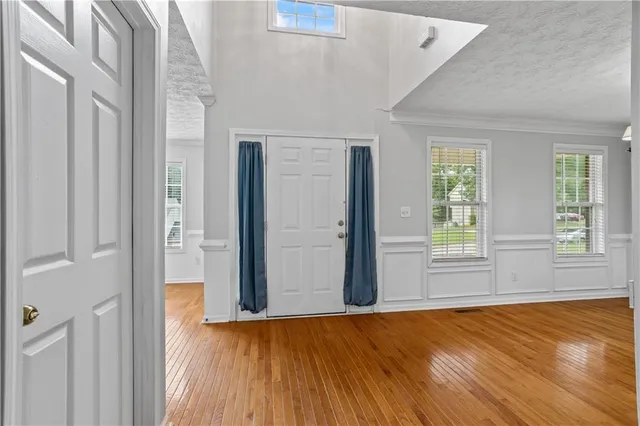 an empty room with wooden floor and windows