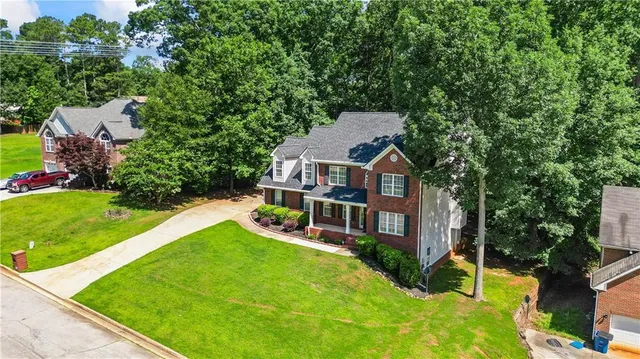 a aerial view of a house with swimming pool next to a big yard