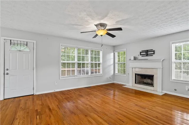 an empty room with windows and fireplace