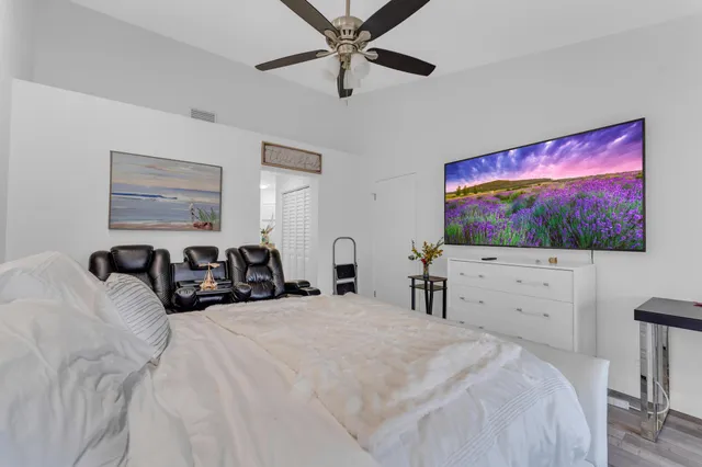 a large bedroom with a bed and a flat screen tv