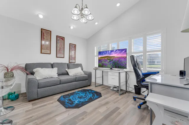 a living room with furniture a flat screen tv and a window