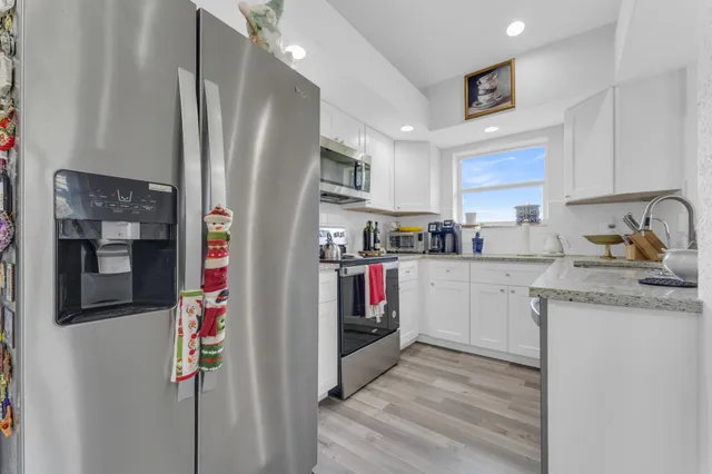 a kitchen with stainless steel appliances granite countertop a refrigerator and a sink