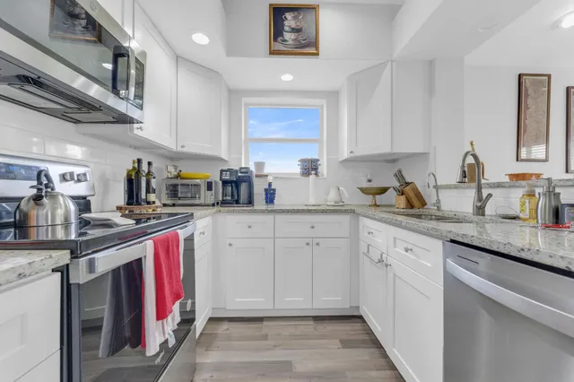 a kitchen with stainless steel appliances granite countertop a sink stove and cabinets
