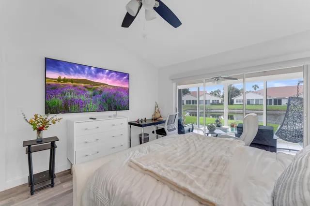 a bedroom with a bed and large windows
