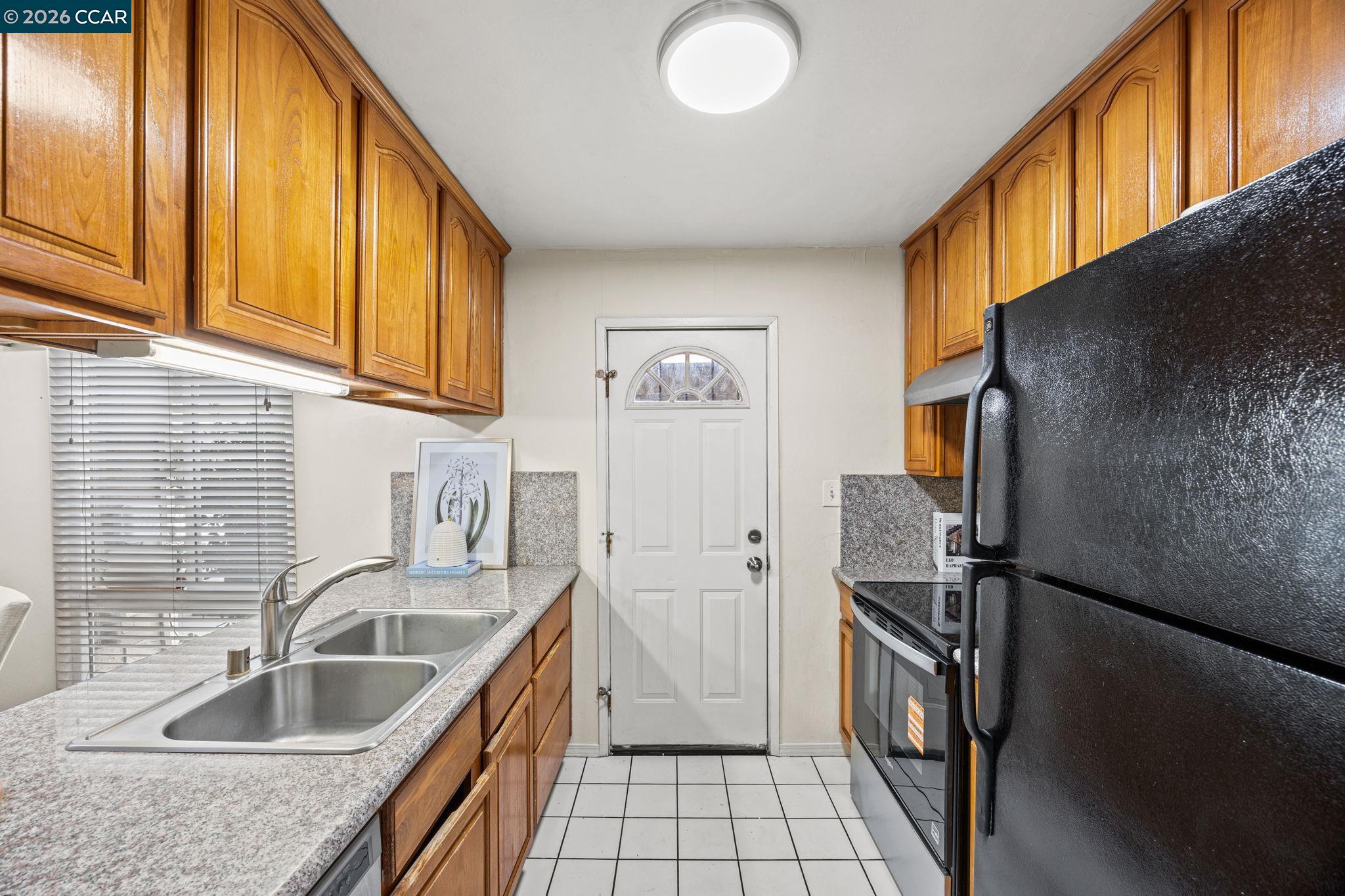 2069 Olivera Road, Unit E Concord, CA 94520 - Photo 5 of 18 a kitchen with a sink a refrigerator and cabinets