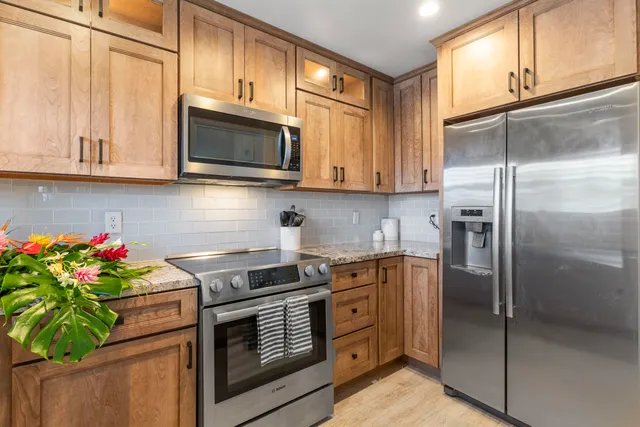 a kitchen with stainless steel appliances granite countertop a refrigerator sink and cabinets