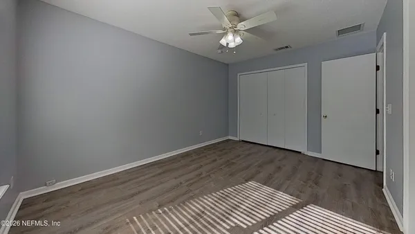 a view of an empty room with wooden floor