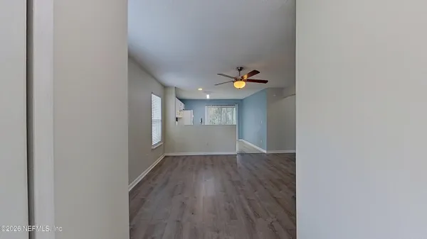 a view of empty room with wooden floor