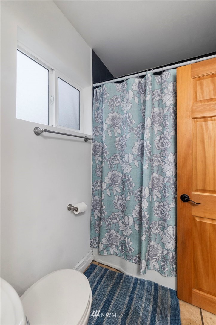 18349 Albany Street Southwest Rochester, WA 98579 - Photo 14 of 21 a white toilet sitting next to a shower curtain