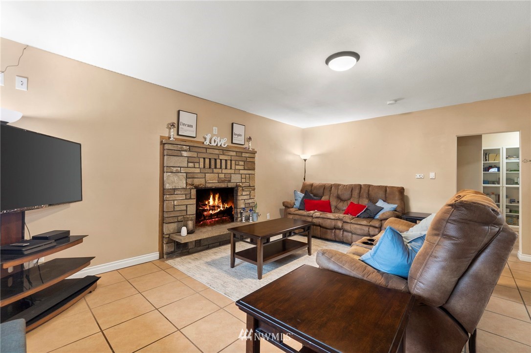 18349 Albany Street Southwest Rochester, WA 98579 - Photo 4 of 21 a living room with furniture a flat screen tv and a fireplace