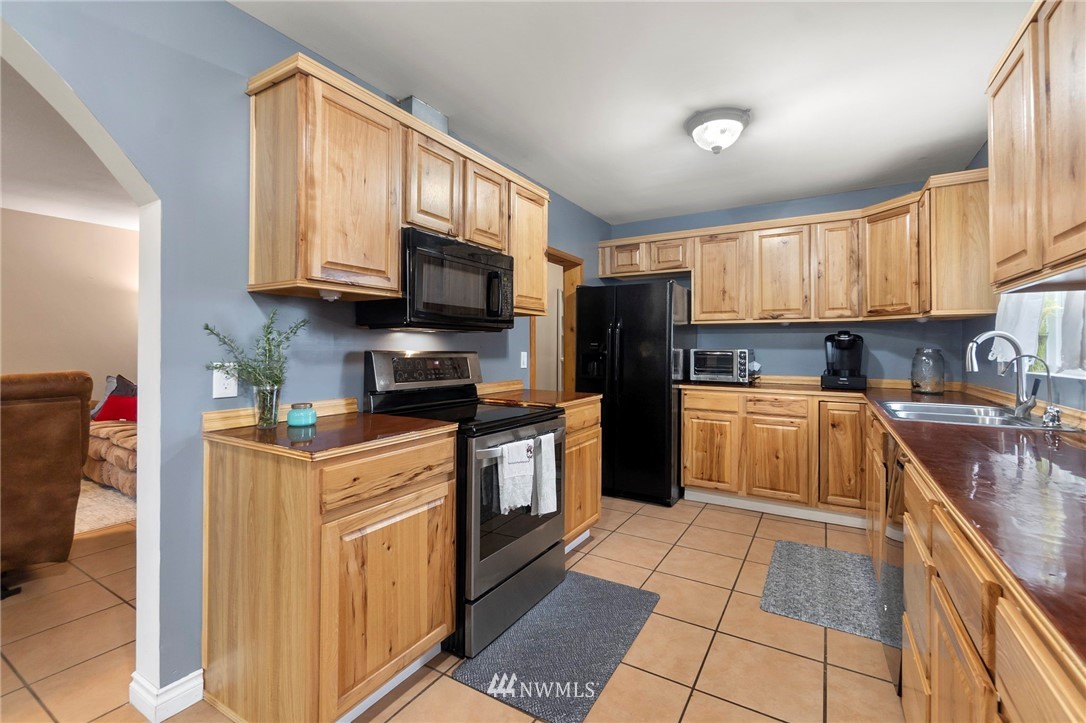 18349 Albany Street Southwest Rochester, WA 98579 - Photo 8 of 21 a kitchen with stainless steel appliances granite countertop a stove top oven a sink dishwasher a refrigerator and cabinets with wooden floor