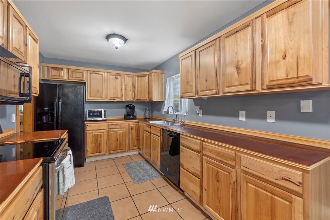 18349 Albany Street Southwest Rochester, WA 98579 - Photo 9 of 21 a kitchen with stainless steel appliances granite countertop a refrigerator sink and cabinets