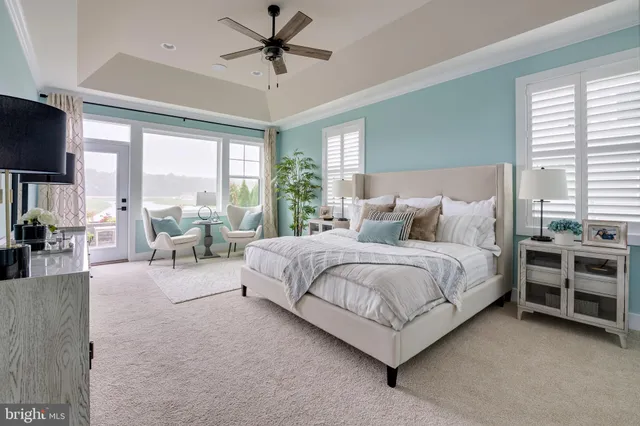 a bedroom with a large bed and a chandelier fan
