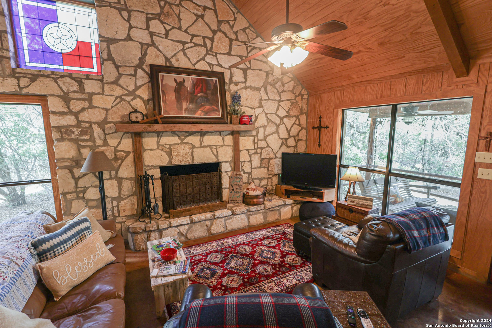 1177 River Road Concan, TX 78838 - Photo 10 of 34 a living room with furniture a flat screen tv and a fireplace