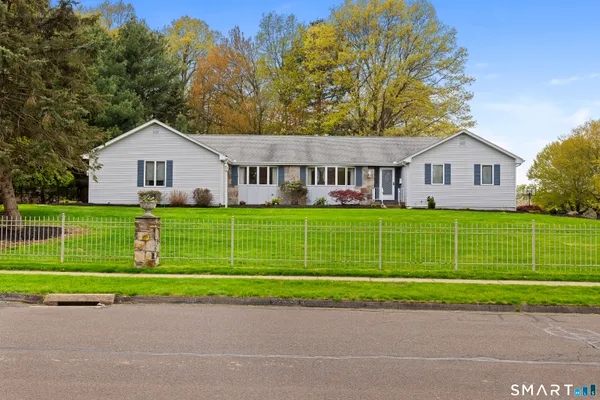 a view of a house with a big yard and large trees
