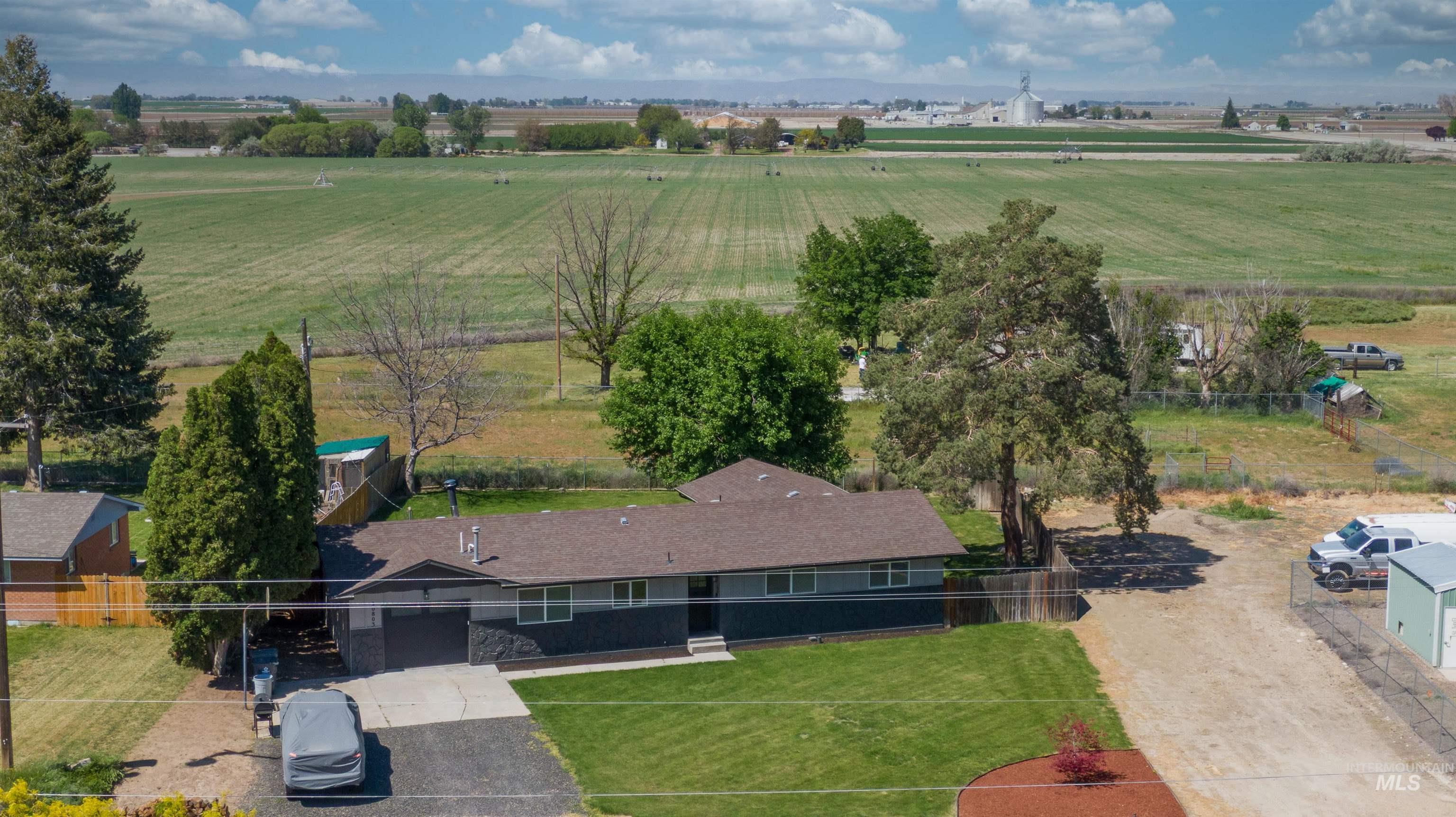 20803 Friends Road Greenleaf, ID 83626 - Photo 2 of 39 Ranch-style residence featuring a dark gray and light gray exterior, an attached garage, and a brown shingle roof