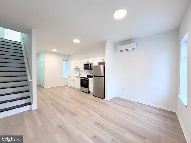 a view of kitchen with wooden floor and electronic appliances