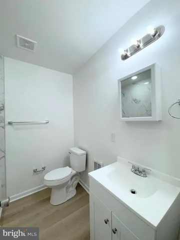a bathroom with a sink a toilet and mirror