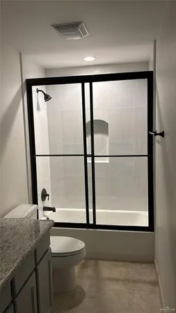 a bathroom with a granite countertop sink a mirror and a bathtub