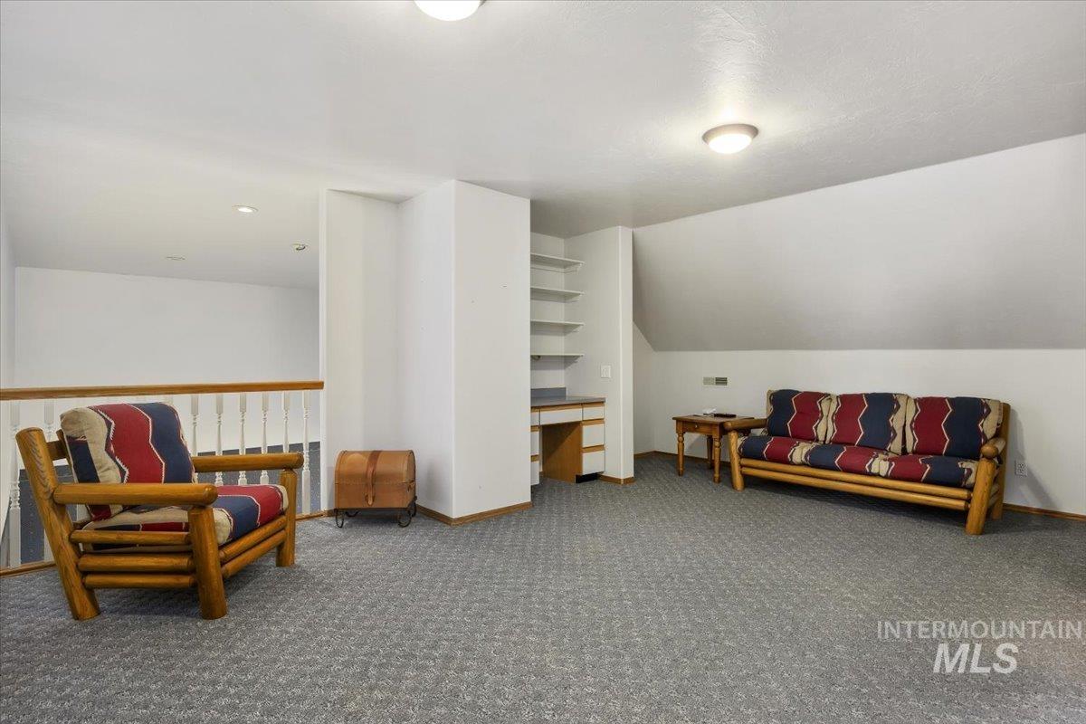 474 Kay Drive Twin Falls, ID 83301 - Photo 23 of 38 Living area featuring carpet flooring, vaulted ceiling, and built in desk