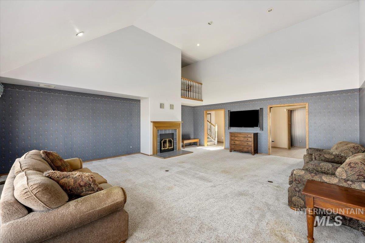 474 Kay Drive Twin Falls, ID 83301 - Photo 5 of 38 Carpeted living room with wallpapered walls, a tiled fireplace, lofted ceiling, and recessed lighting