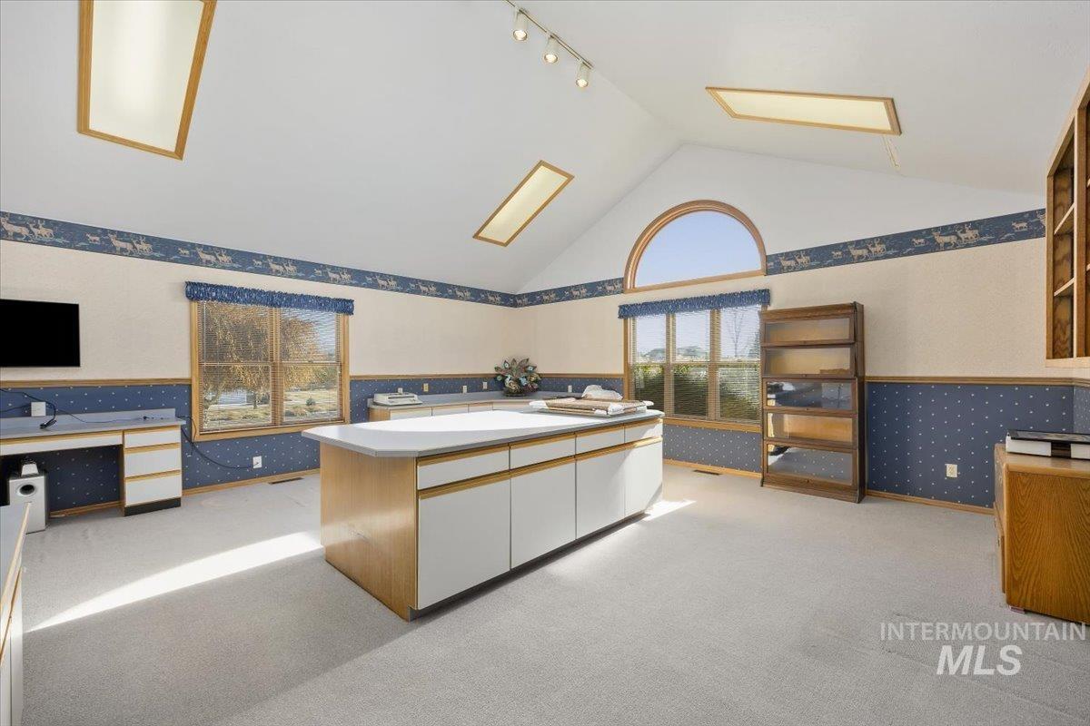 474 Kay Drive Twin Falls, ID 83301 - Photo 9 of 38 Interior space featuring wallpapered walls, light colored carpet, two tone cabinets, rail lighting, and wainscoting