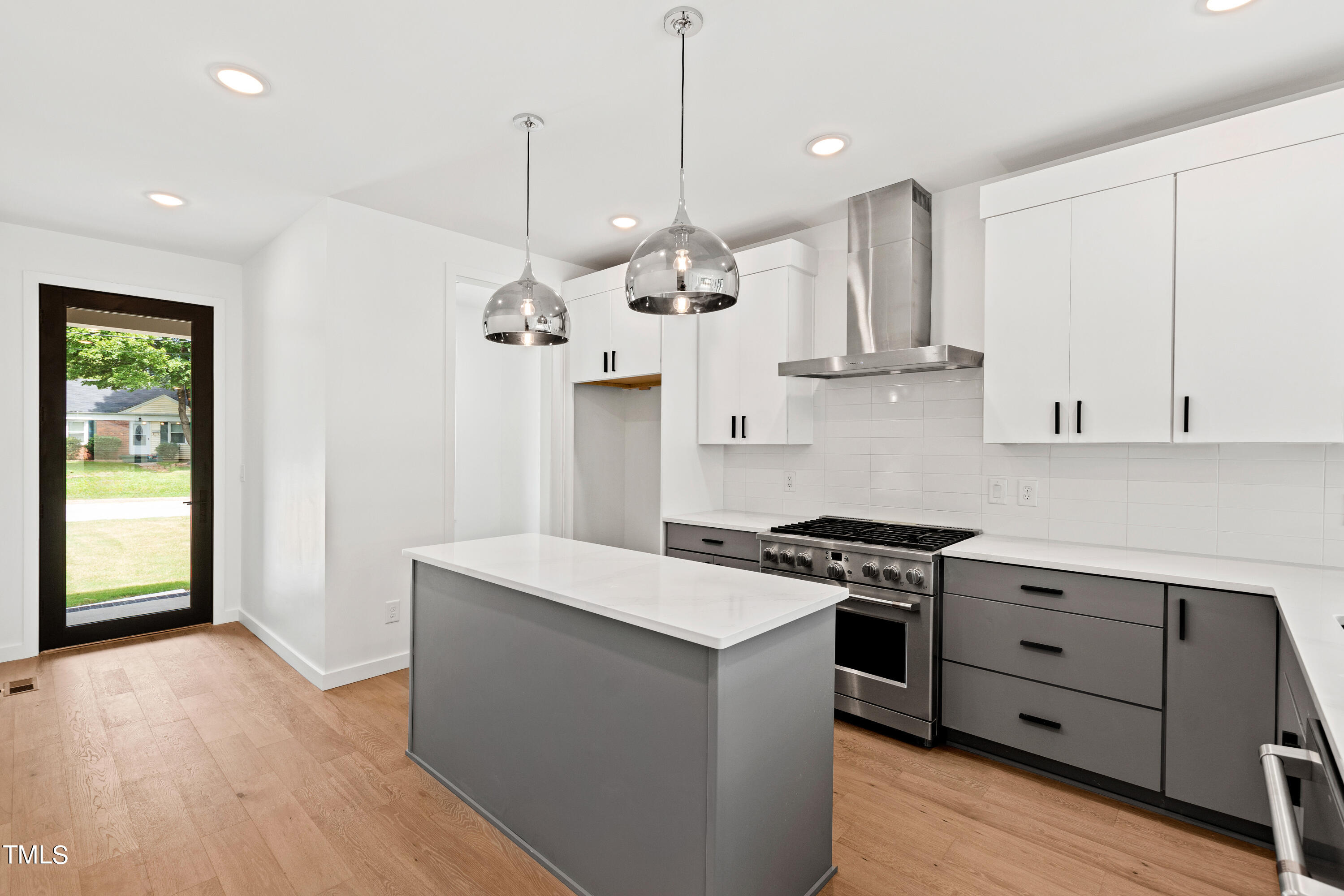 716 Brighton Road, Unit 101 Raleigh, NC 27610 - Photo 19 of 67 a kitchen with stainless steel appliances granite countertop a sink a stove a refrigerator and island with wooden floor