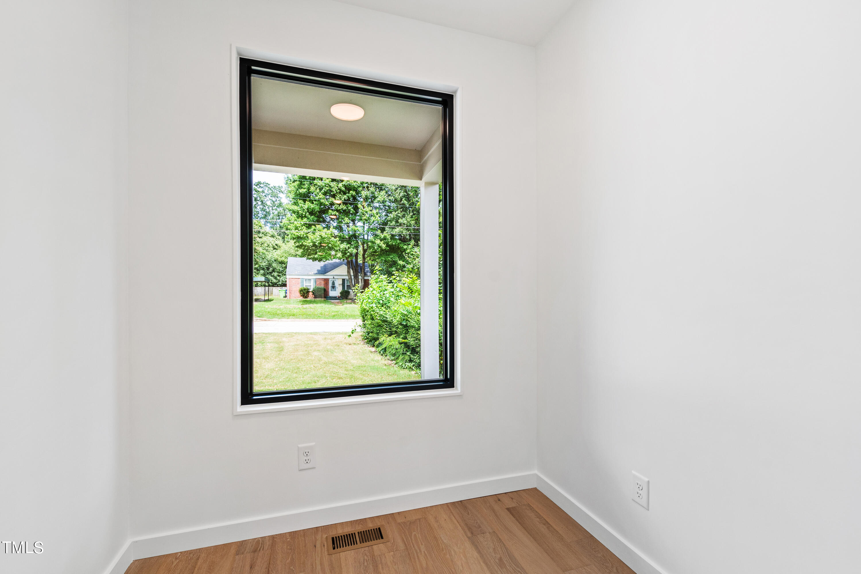 716 Brighton Road, Unit 101 Raleigh, NC 27610 - Photo 25 of 67 a view of an empty room with wooden floor and a window