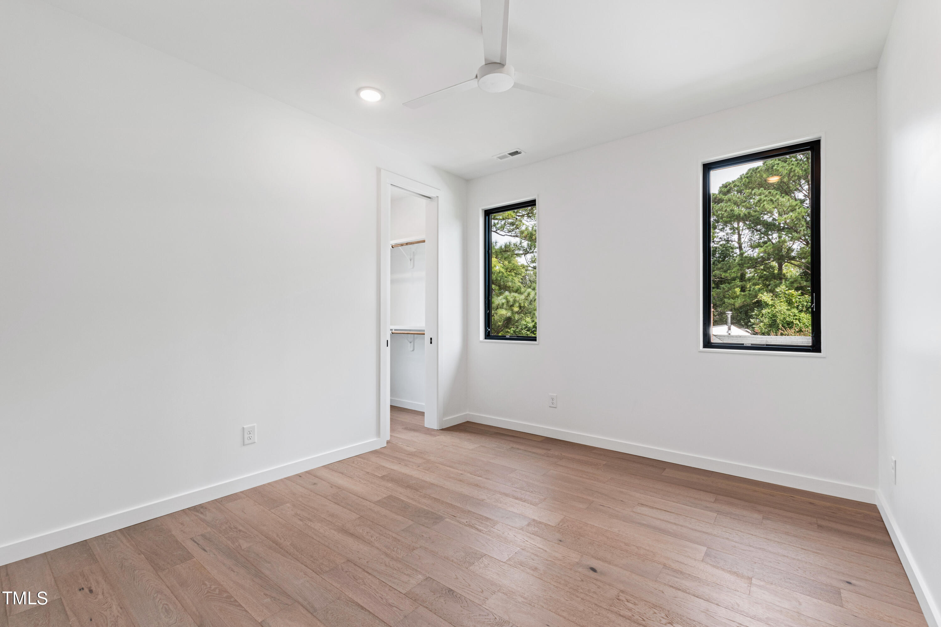 716 Brighton Road, Unit 101 Raleigh, NC 27610 - Photo 47 of 67 an empty room with wooden floor and windows