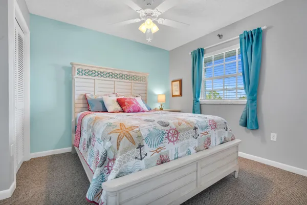 a view of a patio with table and chairs under an umbrella with large trees