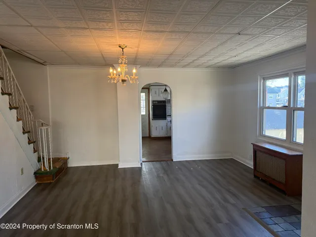 a view of a room with wooden floors and chandelier