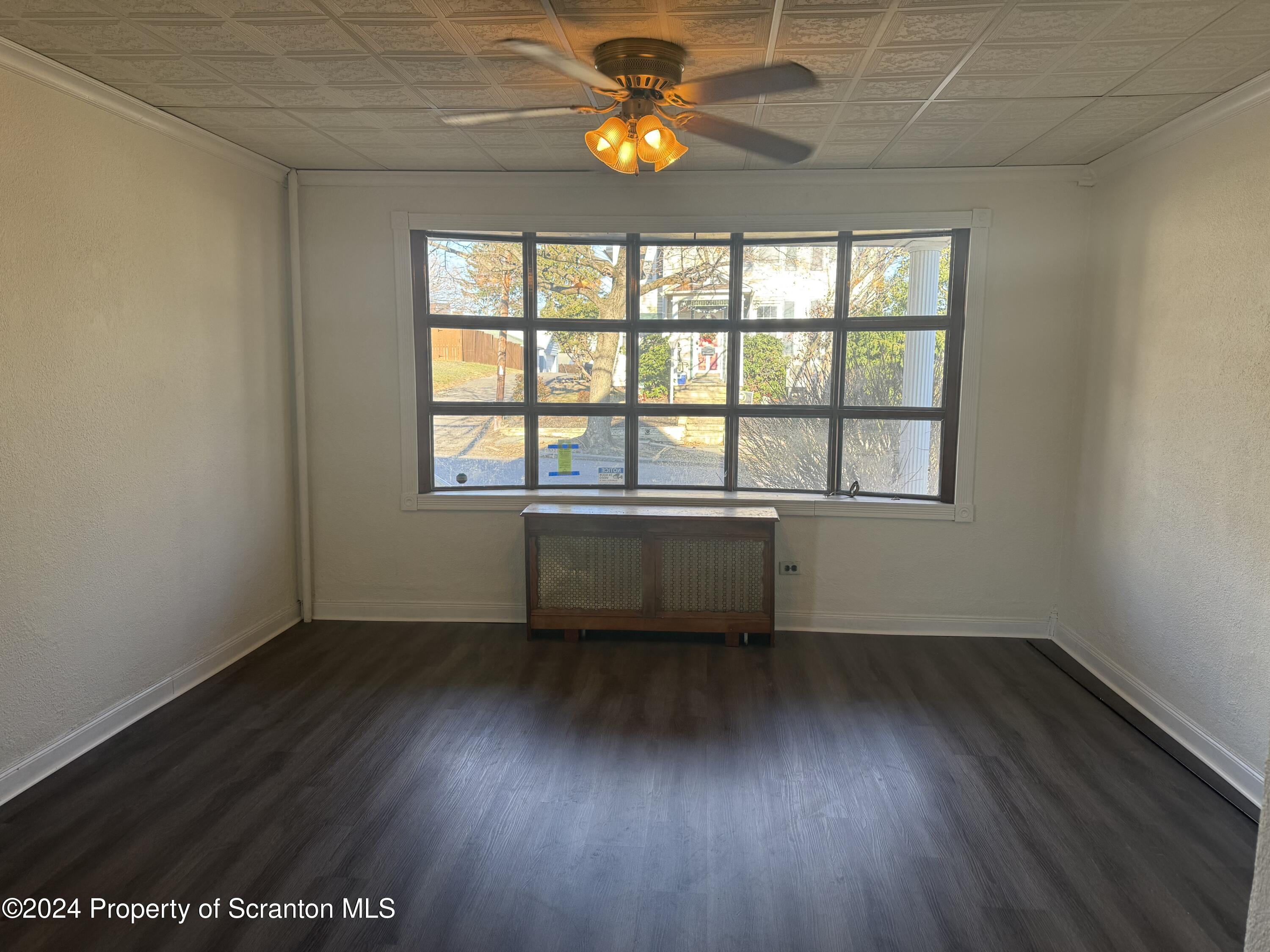 1413 Swetland Street Scranton, PA 18504 - Photo 4 of 9 an empty room with wooden floor and windows