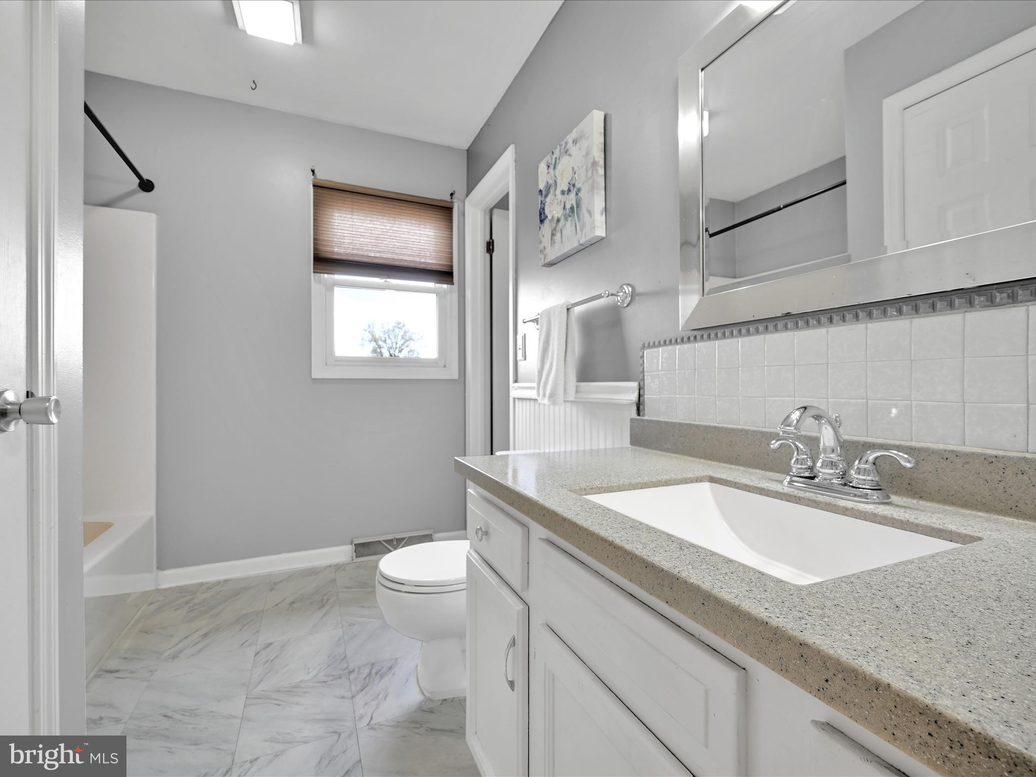 2140 Walnut Street Lebanon, PA 17042 - Photo 18 of 26 a bathroom with a granite countertop sink a toilet a mirror and shower