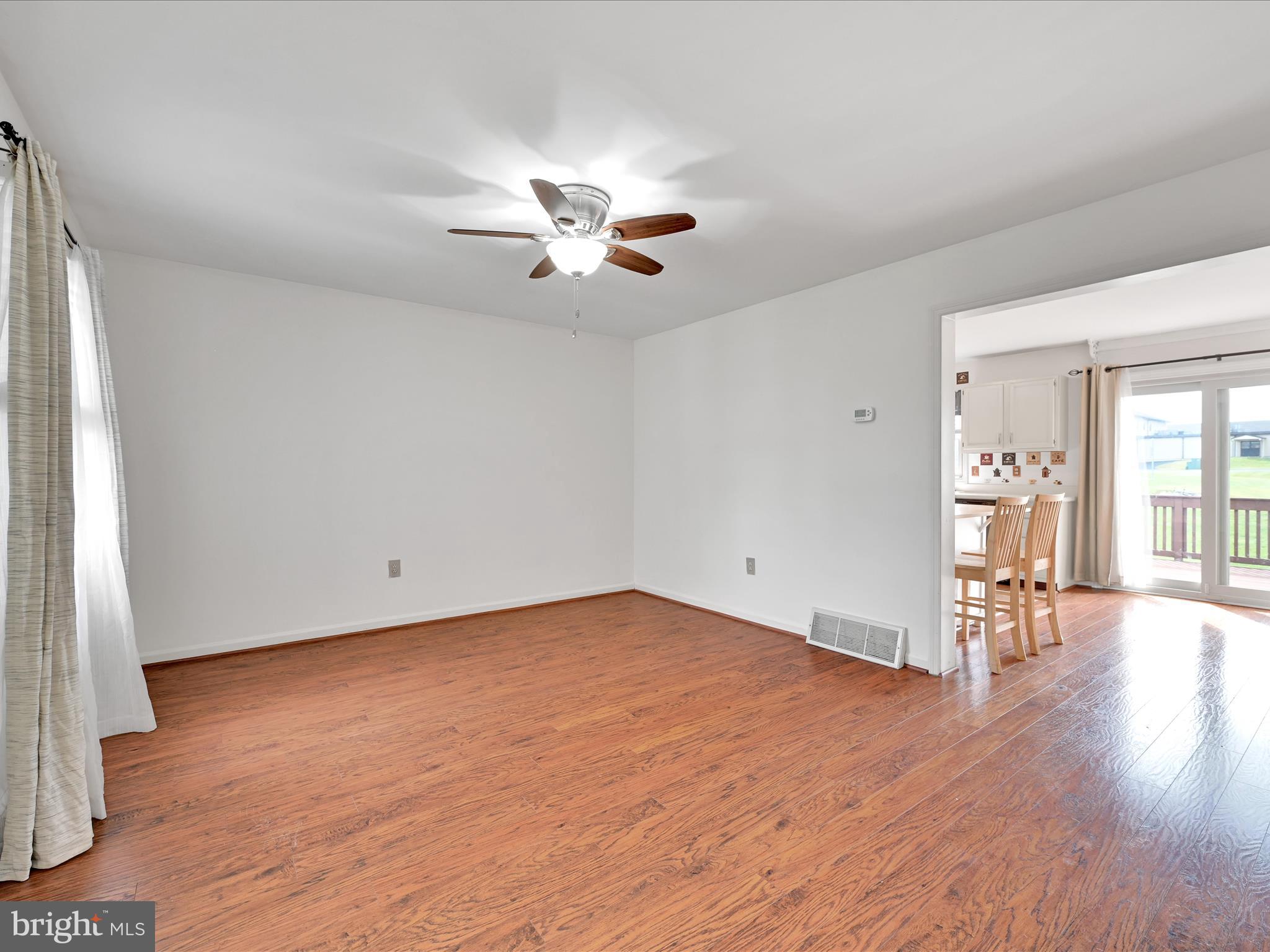 2140 Walnut Street Lebanon, PA 17042 - Photo 4 of 26 an empty room with wooden floor chandelier fan and windows