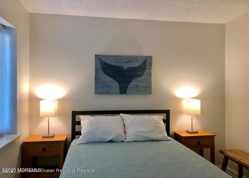 1 2nd Avenue, Unit 3 Seaside Heights, NJ 08751 - Photo 10 of 14 a bedroom with a bed and a lamp