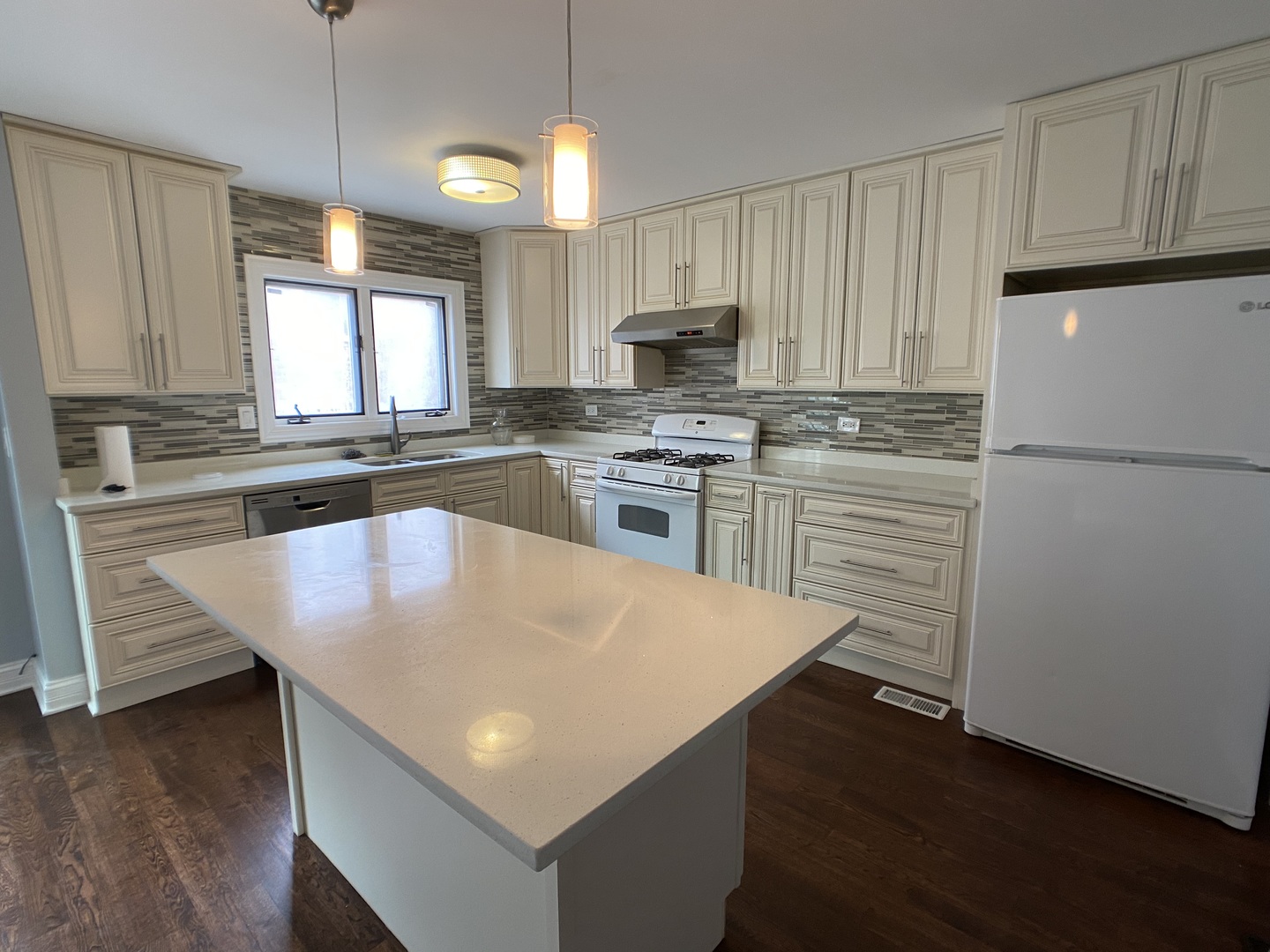2949 South Halsted Street, Unit B Chicago, IL 60608 - Photo 4 of 22 a kitchen with stainless steel appliances granite countertop a sink a stove a refrigerator and island with wooden floor