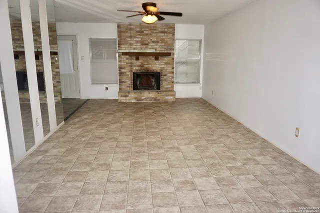 a view of an empty room with a fireplace and a window