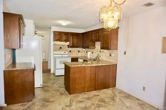 a kitchen with granite countertop a sink stainless steel appliances and cabinets
