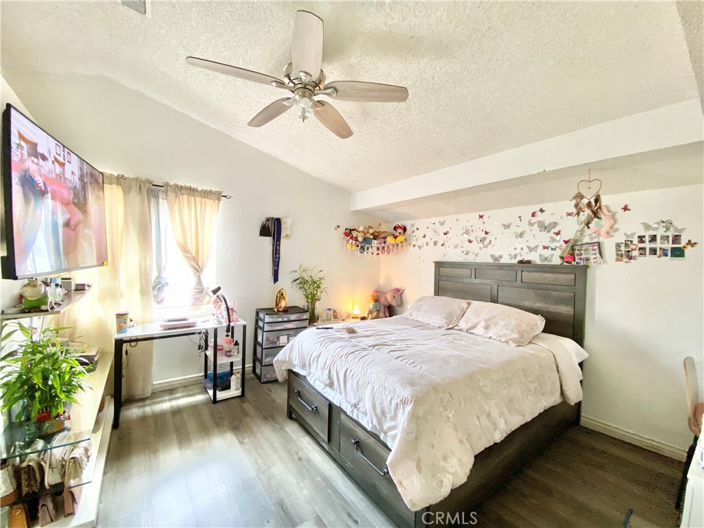 1444 North Sage Avenue Rialto, CA 92376 - Photo 14 of 22 a bedroom with a bed and a chandelier