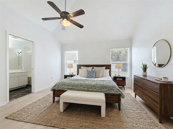 a bedroom with a bed a mirror and table