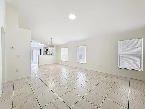 an empty room with windows and chandelier